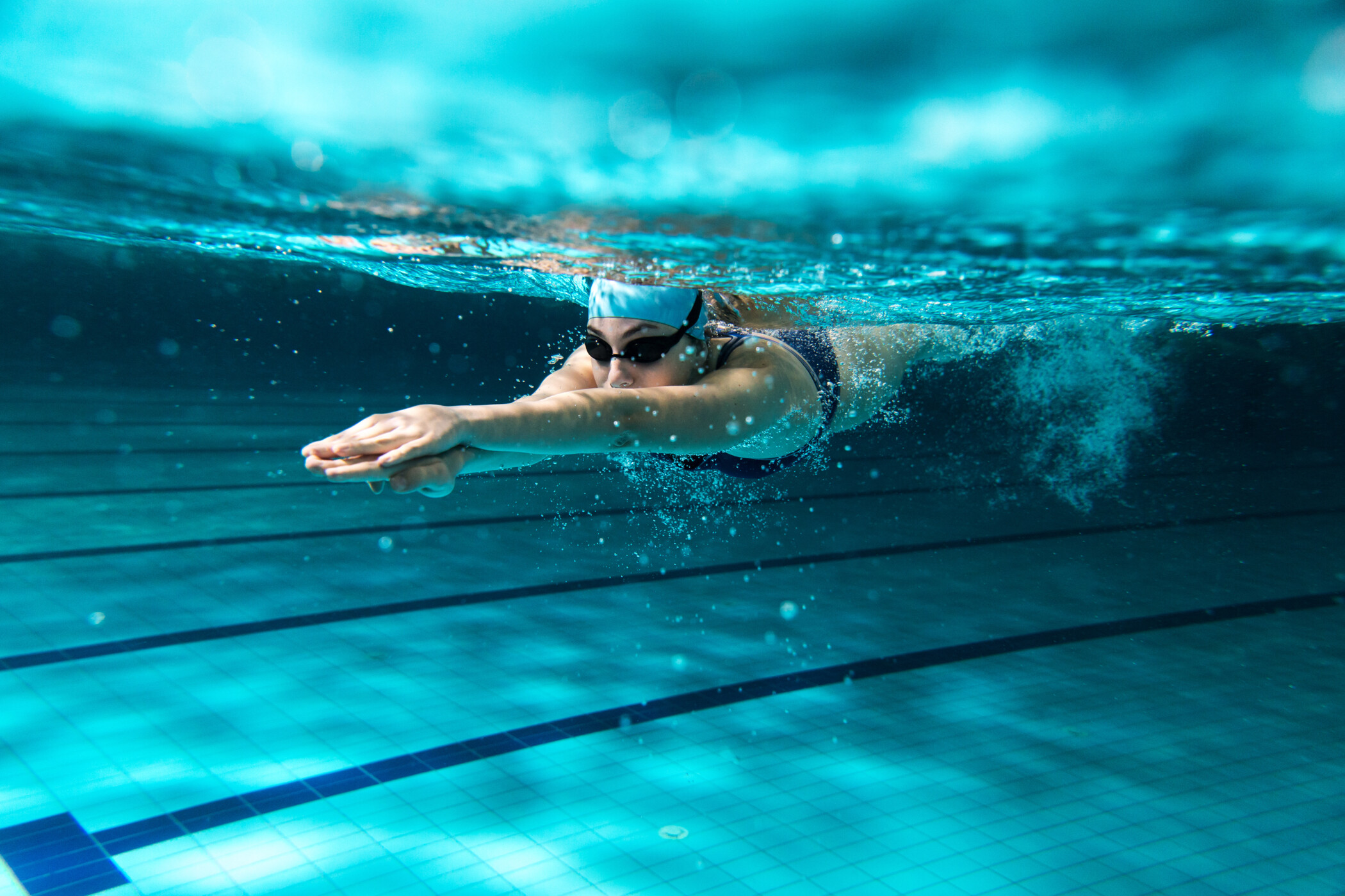 Eine Schwimmerin mit Taucherbrille schwimmt im Pool.